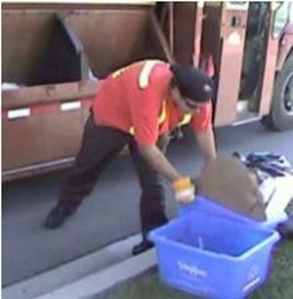 Person bending and twisting their back to pick up a recycling bin. 