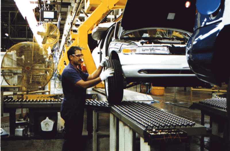 worker installing a tire using the new roller table