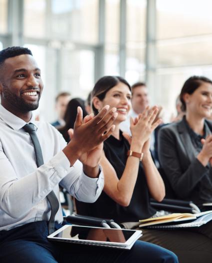 people sitting at a presentation clapping