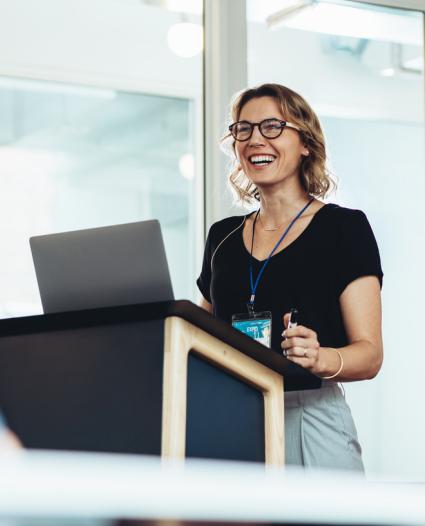 woman giving presentation standing at podium