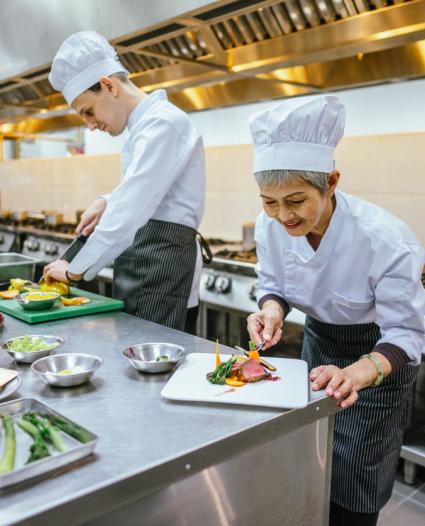 two people preparing food in a restaurant