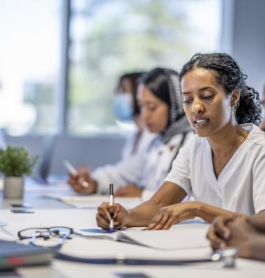 people sitting at a table filling out evaluation forms