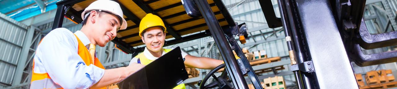 two people talking, one is sitting on a forklift