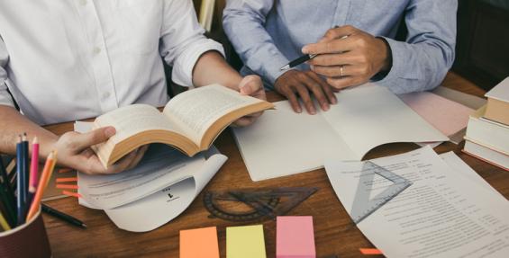 Two people sharing ideas and stories using books