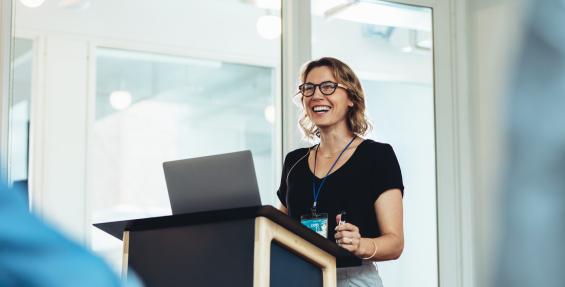 woman giving presentation standing at podium