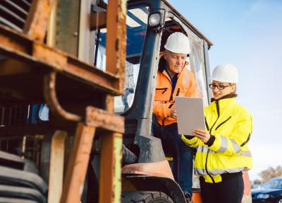 two workers talking beside machinery